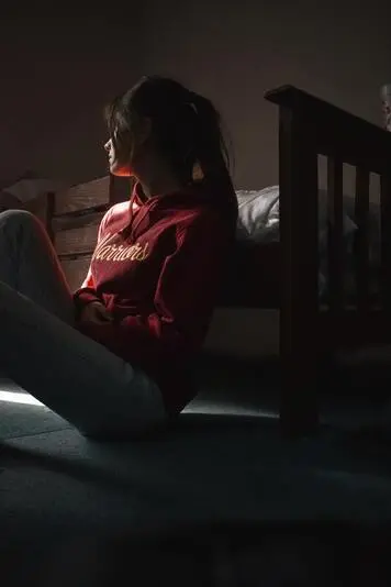 A woman looking contemplative in a dimly lit room